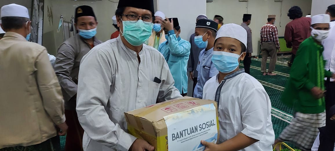 Wakil Ketua DMI Surabaya Nur Hasan menyerahkan bingkisan sembako kepada perwakilan anak yatim. (Foot istimewa)