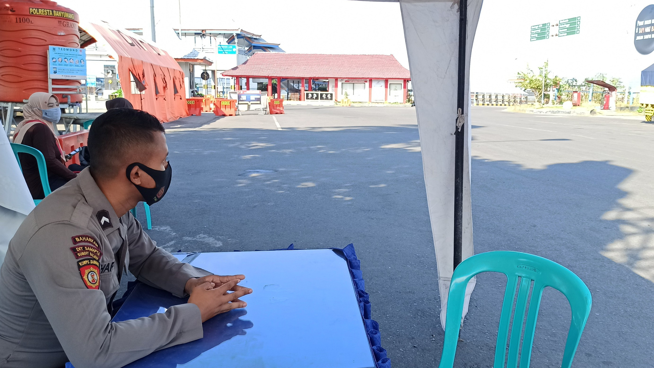Anggota Dalmas Sabhara Polda Jawa Timur berjaga di dekat Posko check point penyekatan di Pelabuhan Ketapang (foto:Muh Hujaini/Ngopibareng.id)