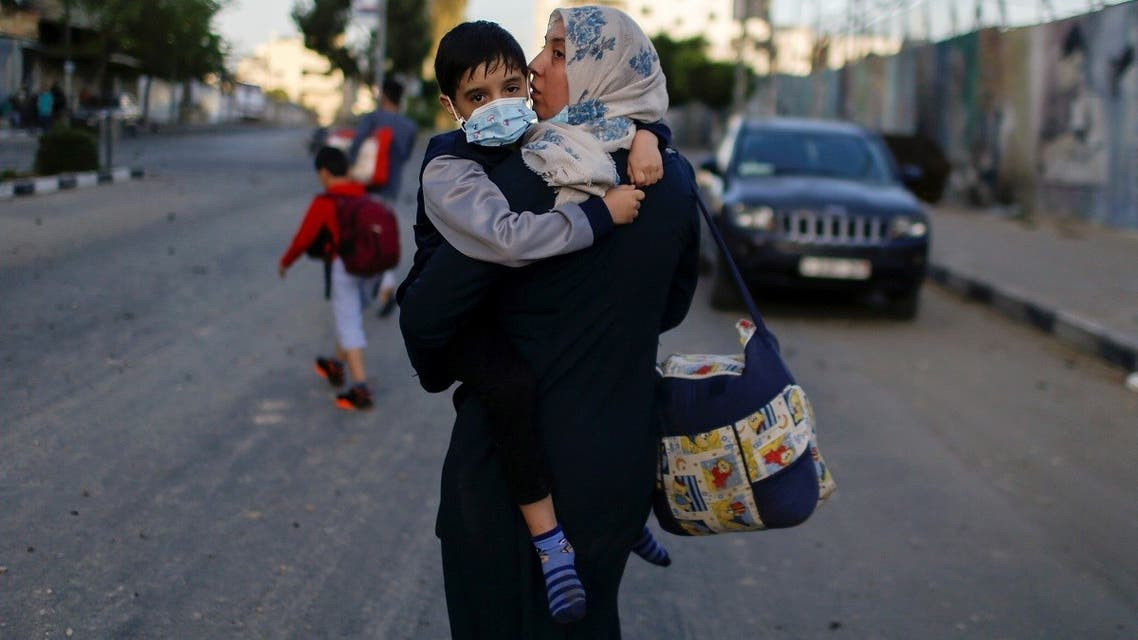 Seorang ibu bersama anaknya, sedang melewati jalan di Jalur Gaza yang makin menegangkan. (Al Arabiya News)