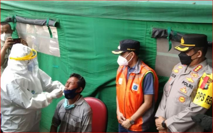 Petugas medis melakukan tes usap antigen kepada seorang warga setelah kembali ke Jakarta usai mudik serangkaian Idul Fitri 1442 Hijriah. (Foto: Antara/Dewa Ketut Sudiarta Wiguna)