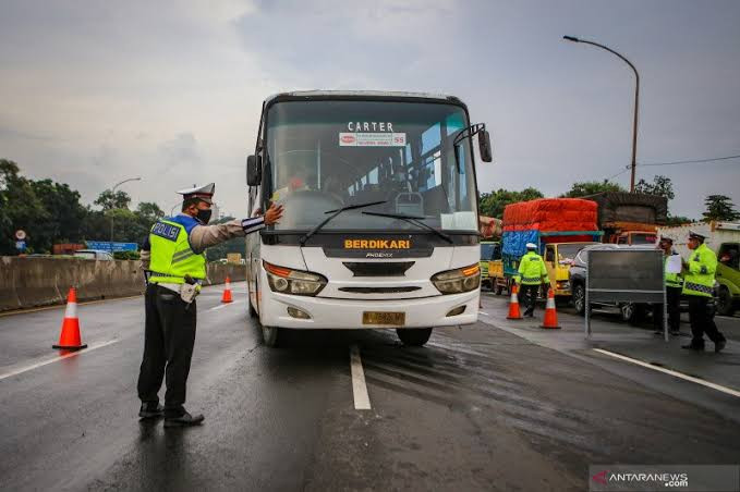 Ilustrasi petugas kepolisian mencegat bus terkait larangan mudik. (Foto: Istimewa)