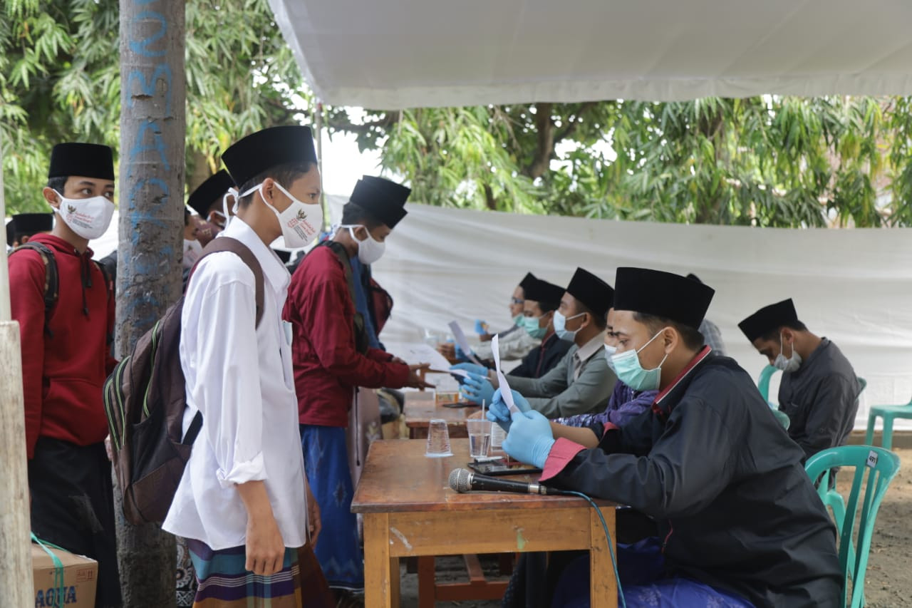 Para santri harus melewati pemeriksaan suhu sekaligus memperlihatkan surat bebas Covid-19 sebelum masuk kembali ke lingkungan pondok pesantren Lirboyo, Kediri, Jawa Timur. (Foto: Istimewa)