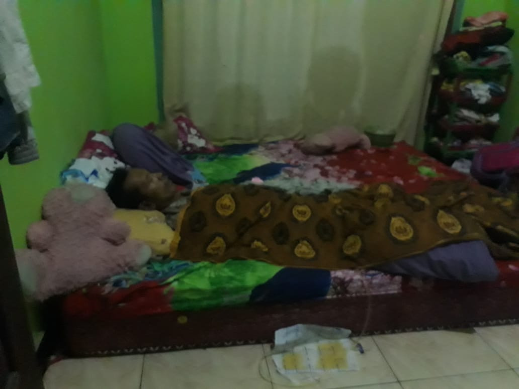 Nur Rockhim terbaring di kasur rumahnya setelah menjalani opname. Dia diduga mengalami kelumpuhan usai mendapatkan vaksin Covid-19. (Foto: Choirul Anam/Ngopibareng.id)