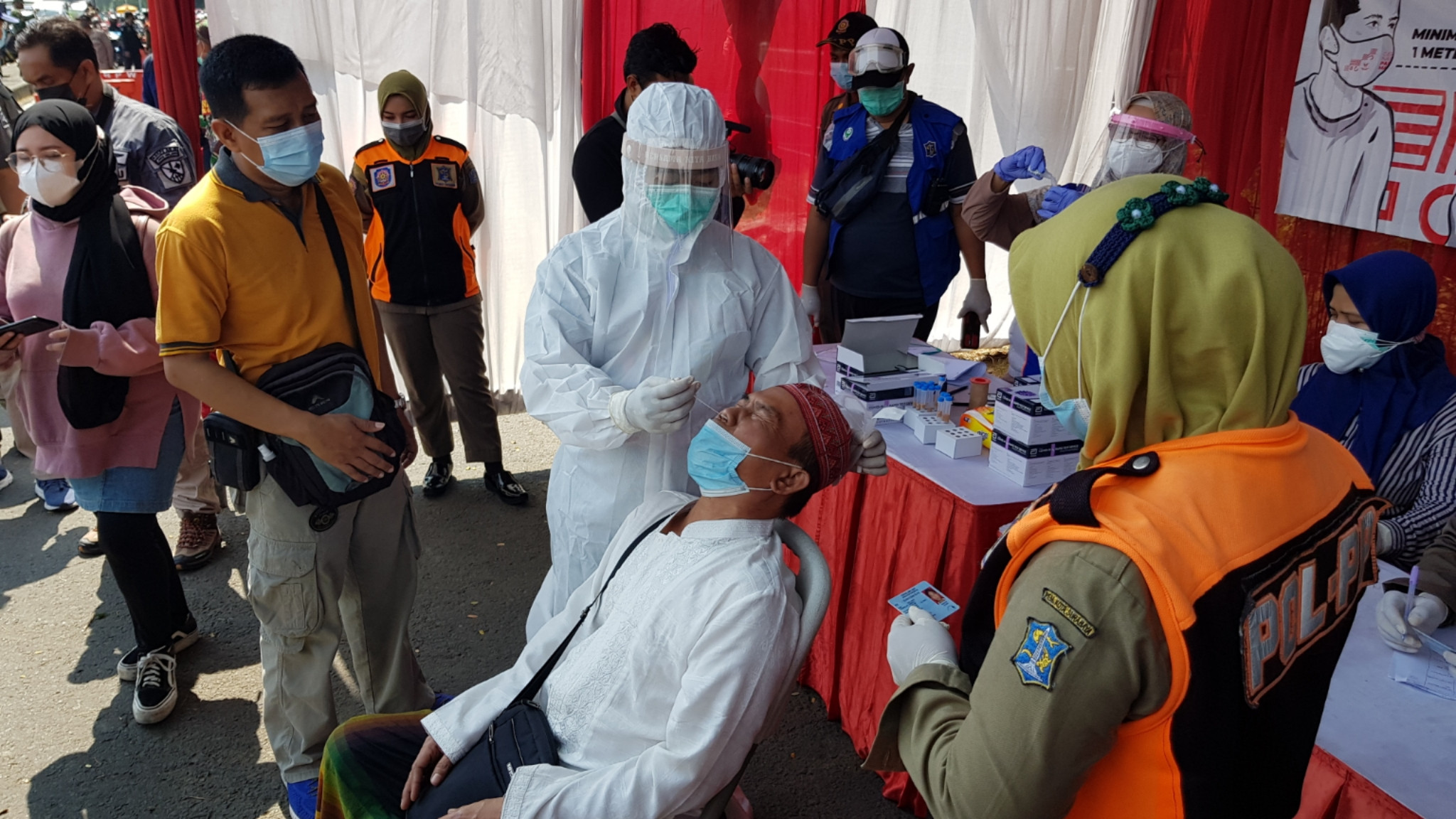 Petugas melakukan swab antigen kepada warga yang akan pulang mudik di Posko Suramadu, Surabaya, Sabtu 22 Mei 2021. (Foto: Fariz Yarbo/Ngopibareng.id)