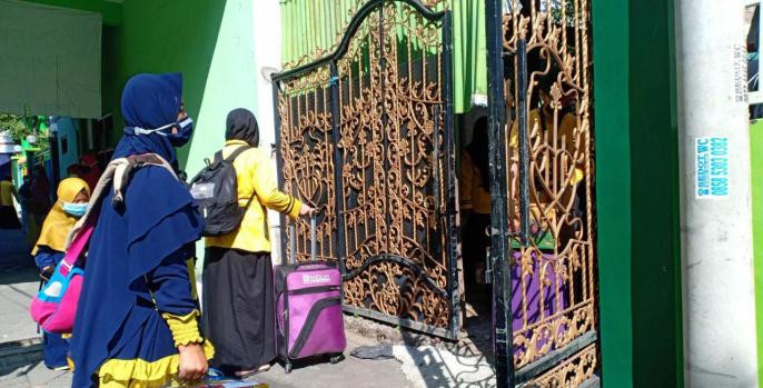 Santriwati di Ponpes Putri Wahid Hasyim Bangil, Pasuruan saat akan memasuki area ponpes. (Foto: pasuruankab.go.id)