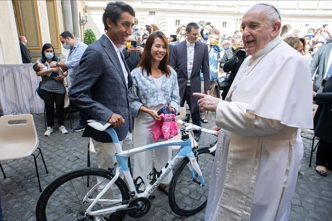 Egan Bernal dan pacarnya memberikan sepeda Pinarello Dogma F12 dan jersey maglia rosa penanda juara Giro d'Italia bertandatangan Bernal ke Paus Francis.