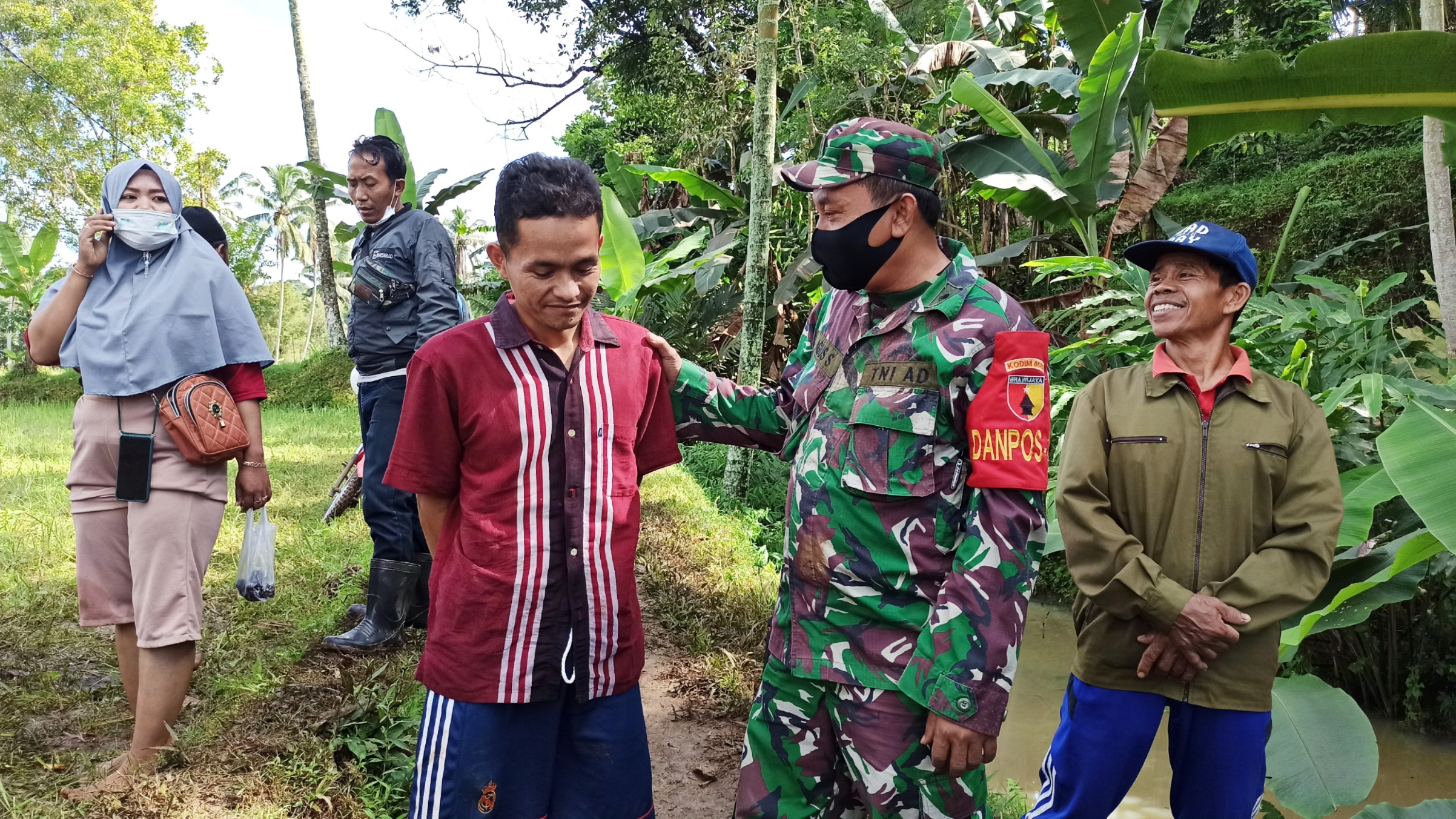 Komandan Pos Ramil Licin Peltu Agus Sugiarto berbincang dengan Bundan, salah satu korban selamat musibah longsor (foto : Muh Hujaini/Ngopibareng.id)