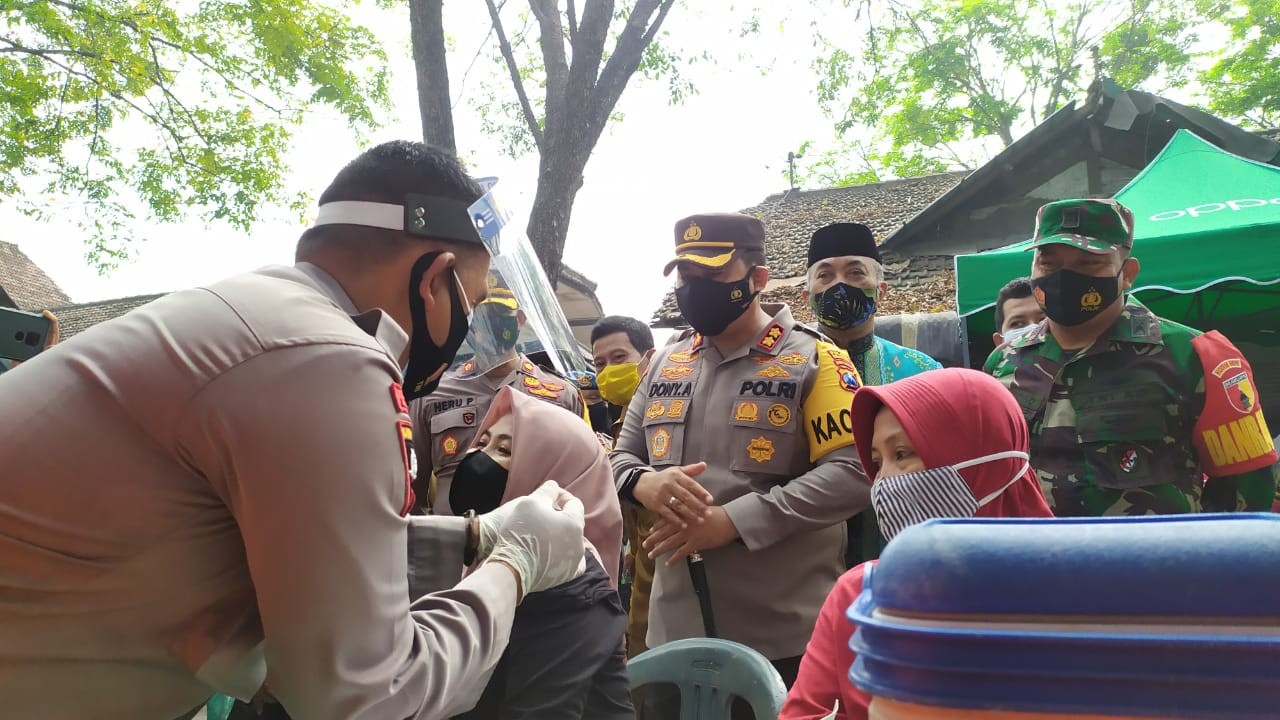 Kapolres Mojokerto saat meninjau vaksinasi massal di pasar legi Kecamatan Mojosari.(Deni Lukmantara/Ngopibareng)