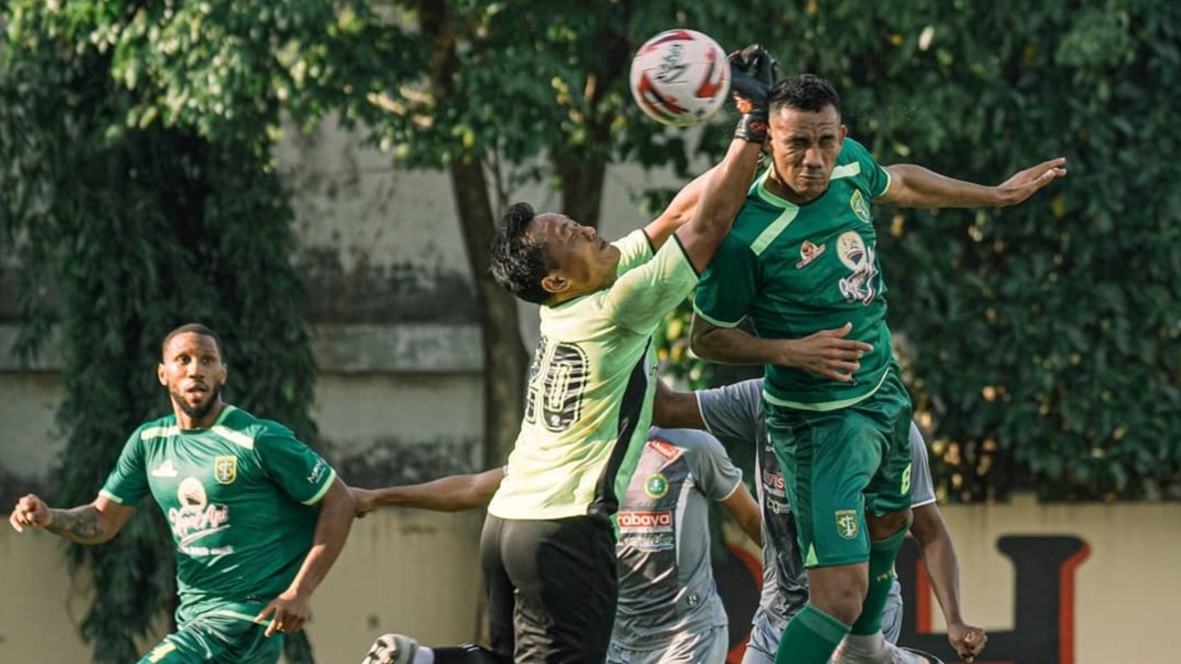 Pemain Persebaya, Jose Wilkson saat berebut bola dengan kiper PSHW dalam laga uji coba di Lapangan Polda Jatim, Surabaya, Selasa 22 Juni 2021. (Foto: Persebaya)