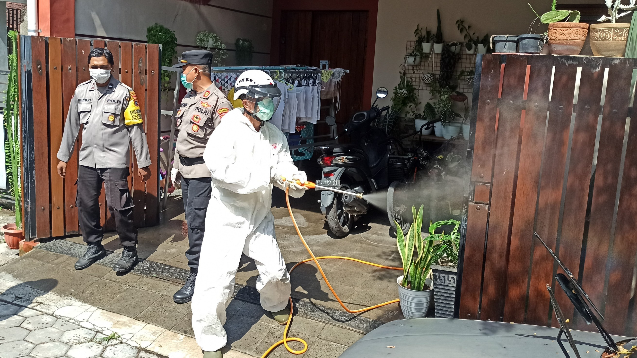 Petugas melakukan penyemprotan disinfektan di rumah warga yang terpapar Covid-19 (foto :Muh Hujaini/Ngopibareng.id)