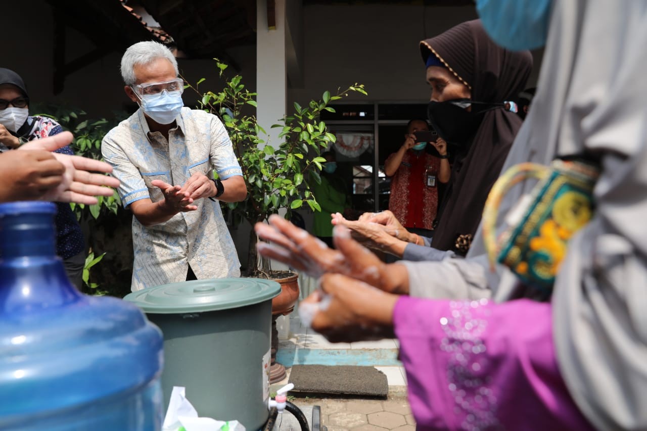 Ganjar Pranowo mengedukasi warga tentang cara mencuci tangan yang baik dan benar di salah satu desa di Pekalongan, Jawa Tengah. (Foto: Istimewa)