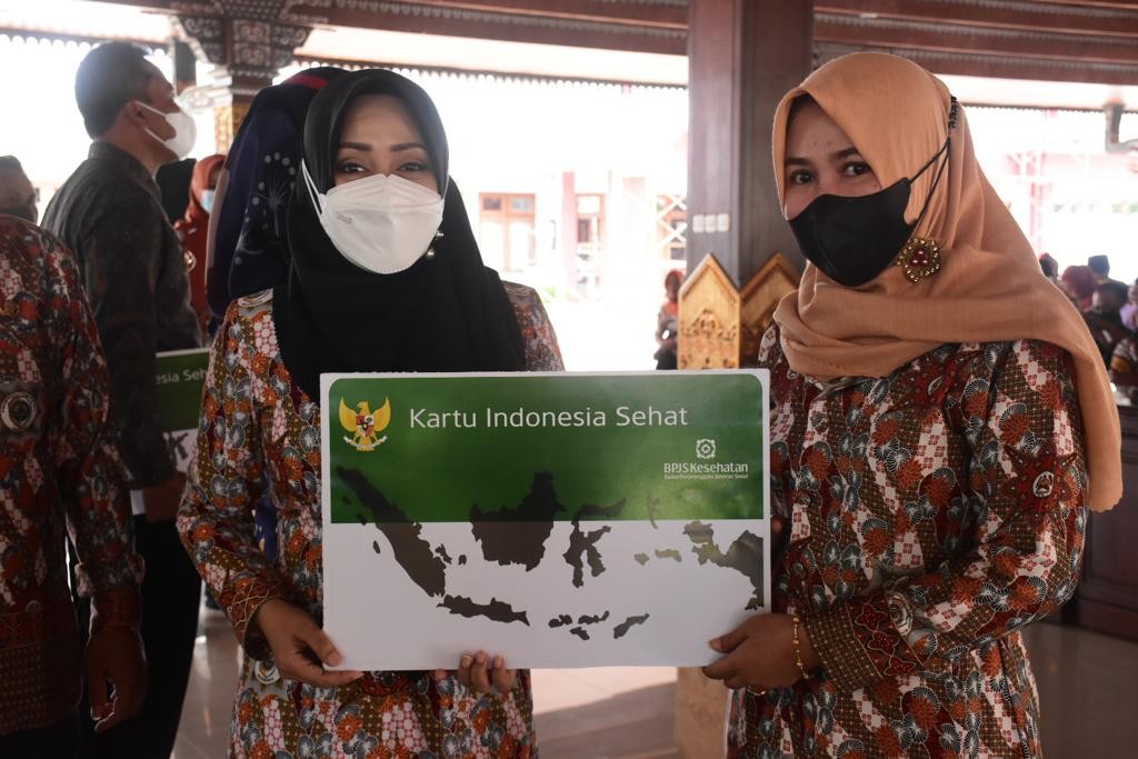 Bupati Mojokerto menyerahkan kartu JKN-KIS secara simbolis kepada perangkat dan kepala desa. (Foto: Deni Lukmantara/Ngopibareng.id)