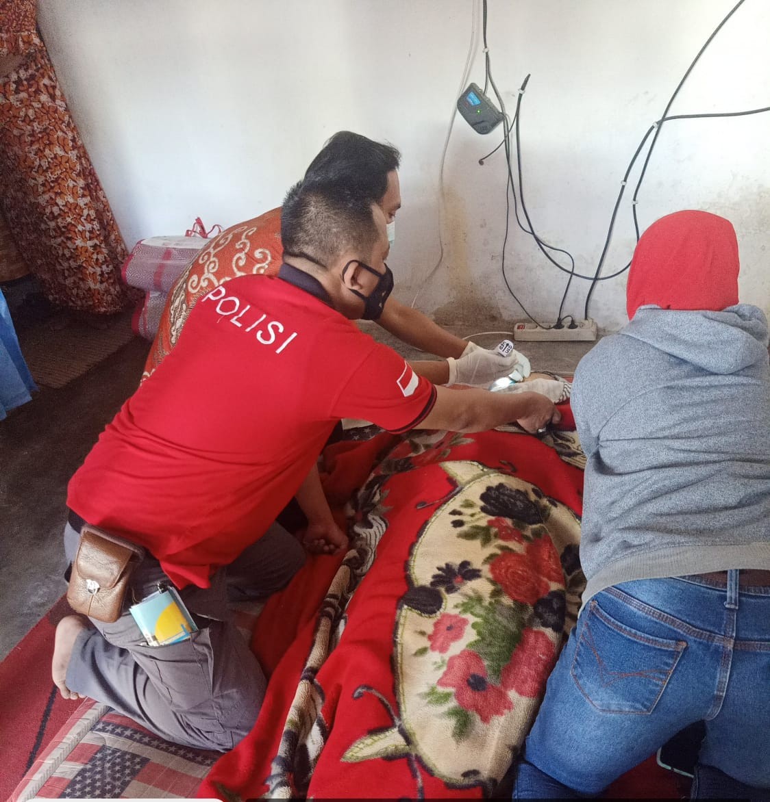 Petugas medis dibantu anggota Polsek Kalisat saat memeriksa jenazah korban (Foto:Istimewa/ngopibareng.id)