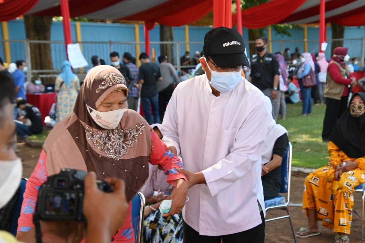 Gus Ipul membantu seorang lansia yang kesulitan berjalan saat vaksinasi massal di Hari Bhayangkara ke-75 di Stadion Untung Suropati, Kota Pasuruan, Sabtu 26 Juni 2021. (Foto: Istimewa)