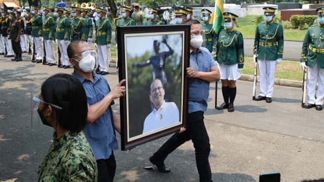 Personel militer Filipina membawa potret mendiang mantan Presiden Benigno Aquino Jr, dalam prosesi pemakaman di sebuah taman pemakaman di Manila (Foto:Ted Aljibe/ AFP)