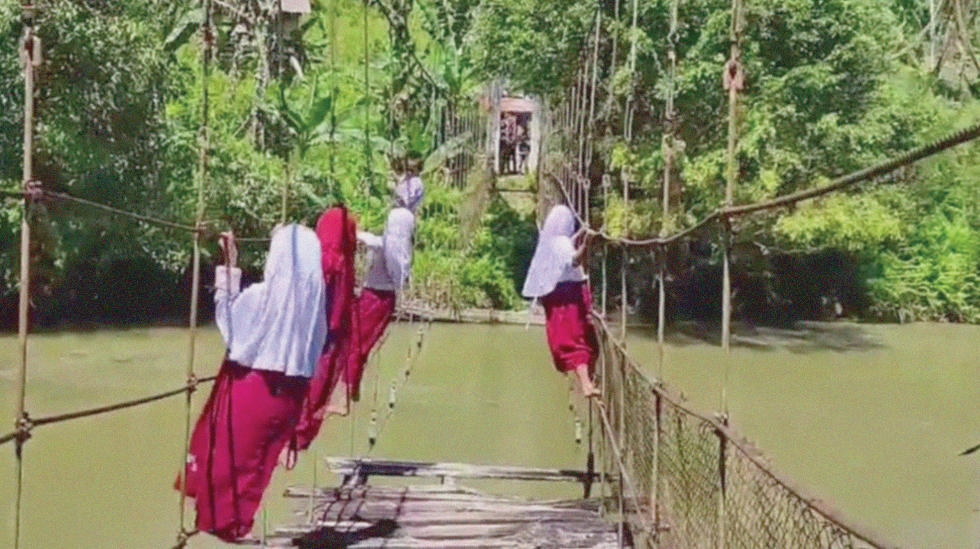 Tangkapan layar siswa SD bergelantungan memegangi tali di jembatan gantung rusak demi berangkat ke sekolah (Foto: Instagram @fakta.indo)