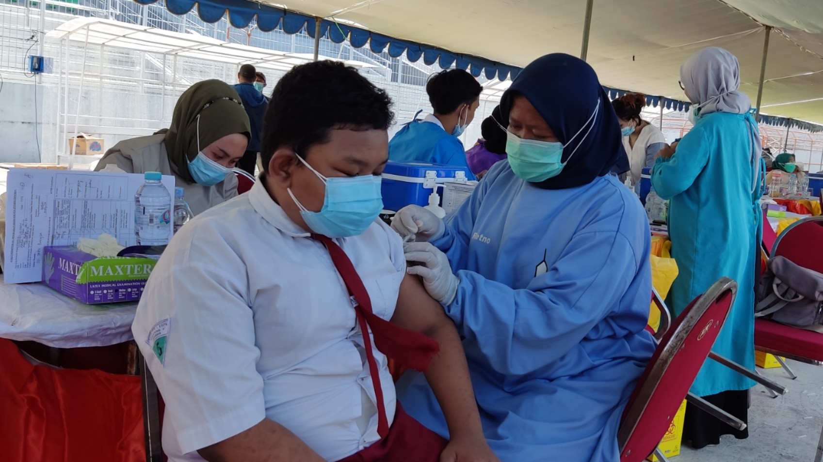 Seorang siswa menjalani vaksinasi di Stadion Gelora 10 November, Surabaya, Minggu 11 Juli 2021. (Foto: Fariz Yarbo/Ngopibareng.id)