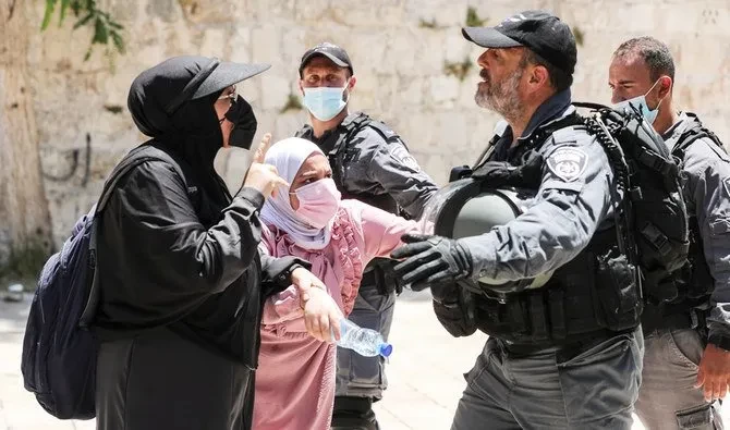 Perempuan Palestina berdebat dengan seorang anggota pasukan keamanan Israel setelah bentrokan singkat meletus antara polisi Israel dan warga Palestina di Masjid Al-Aqsha di Kota Tua Yerusalem, 18 Juli 2021. (Foto: reuters)