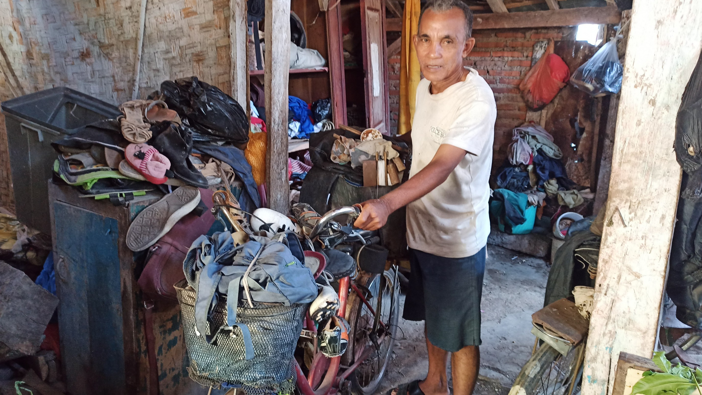 Bakar menunjukkan sepeda yang biasa dia gunakan untuk berkeliling menjadi tukang sol (foto:Muh Hujaini/Ngopibareng.id)