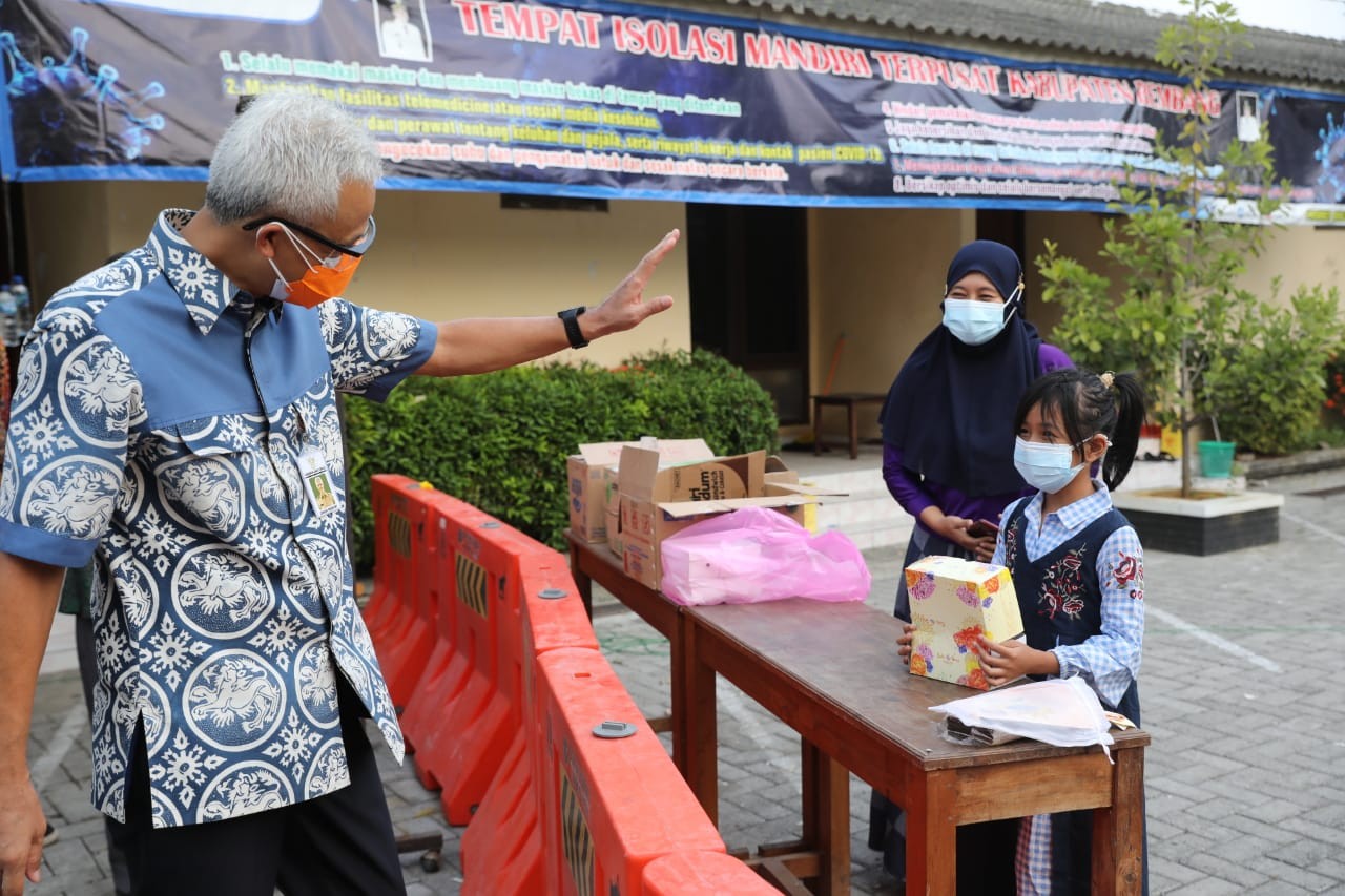 Gubernur Jawa Tengah Ganjar Pranowo saat bercengkerama dengan gadis kecil penghuni lokasi isolasi Covid-19 di Rembang. (Foto: Istimewa)