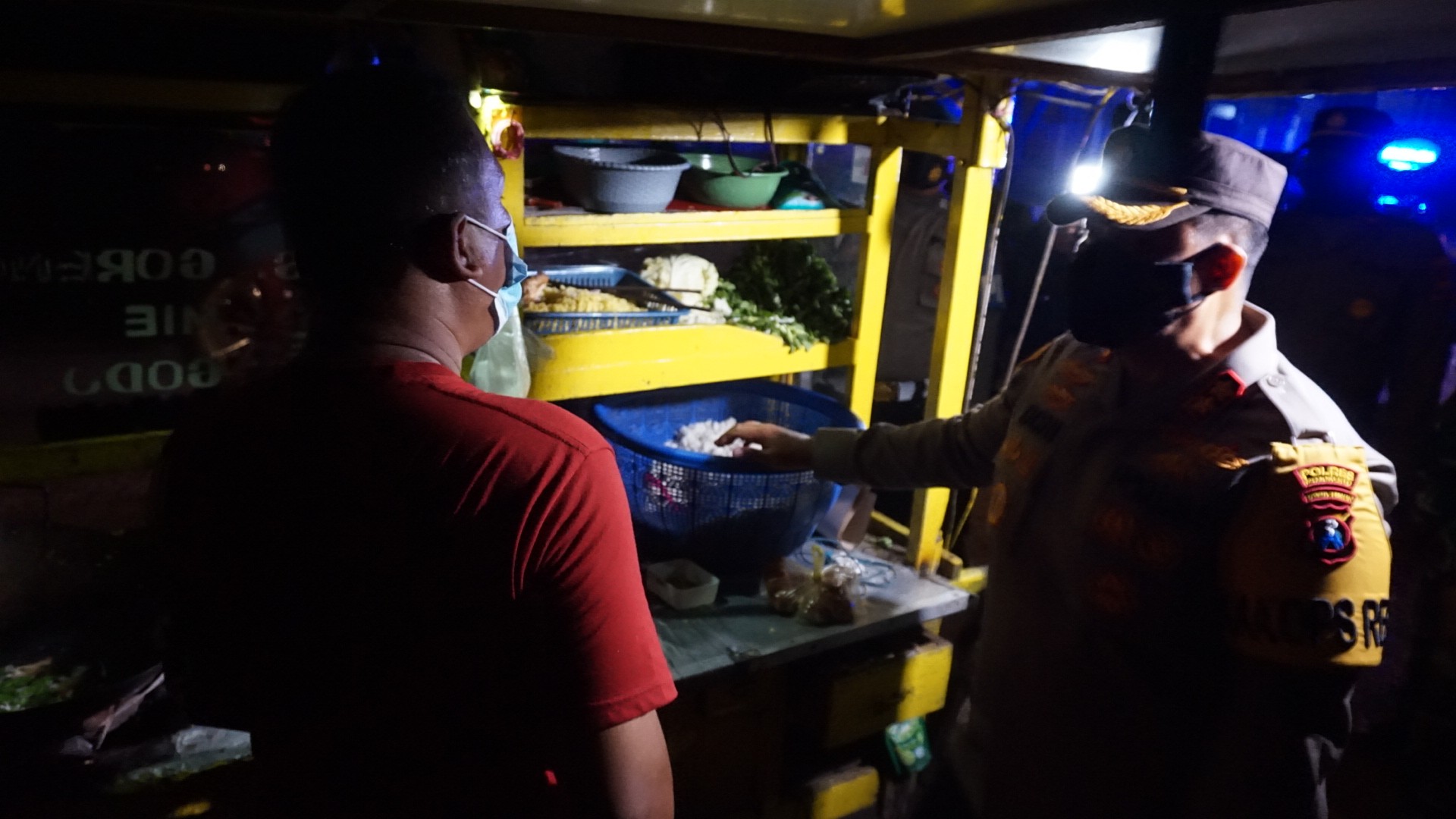 Penjual nasi goreng kaget dagangannya diborong petugas.(Deni Lukmantara/Ngopibareng.id)