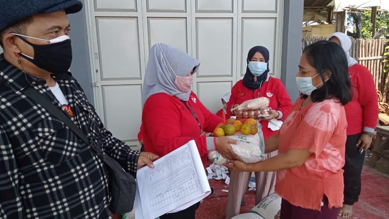 Pendamping PKH Dinkes DKI Jakarta, Sunandar saat pembagian bantuan pangan. (Foto: Asmanu Sudharso/ngopibareng.id)