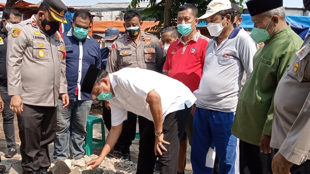 Tokoh masyarakat Andi Jamaro melakukan peletakan batu pertama,  untuk Pospol disaksikan Kapolsek Kebun Jeruk  Kompol Robinson  Manurung (foto: Asmanu/ngopibarreng.id)