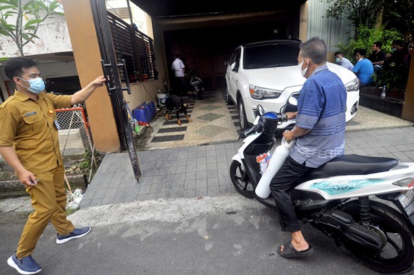 Seorang pria membawa tabung oksigen masuk ke rumah Heryanti kemarin (3/8). Foto-Foto: Sumatera Ekspres (partner Harian Disway)