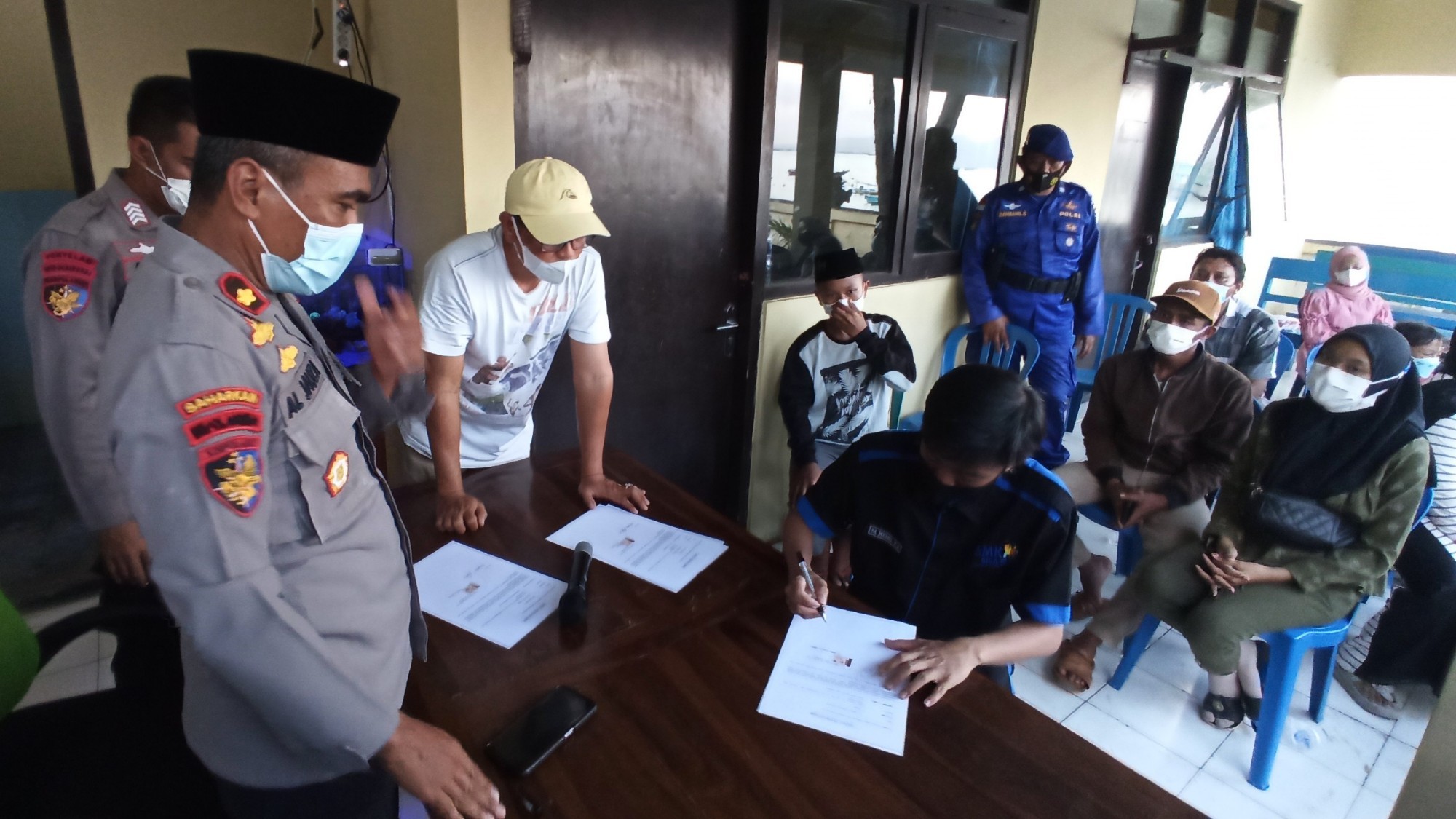 Keluarga korban kapal Nelayan Bintang Sonar yang masih belum ditemukan menandatangani surat pernyataan yang memastikan jenazah yang ditemukan di Plengkung bukan keluarganya (foto:Muh Hujaini/Ngopibareng.id)