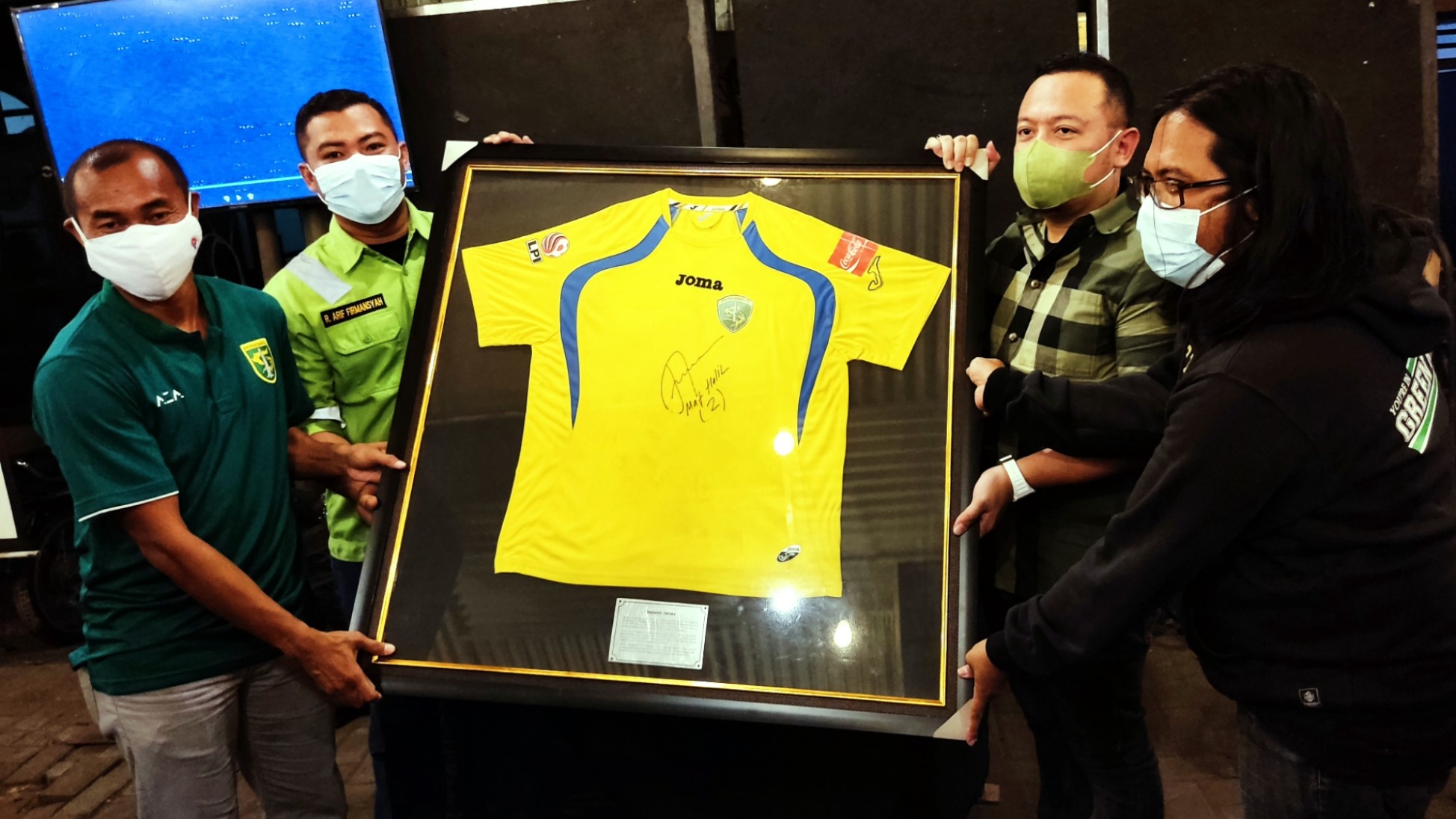 Pemenang lelang, Wahyu Dinar (dua dari kanan) menerima jersey dari Legenda Persebaya Mat Halil dan perwakilan Bonek Green Nord27 di Warkop Pitulikur, Surabaya, Jumat 6 Agustus 2021. (Foto: Fariz Yarbo/Ngopibareng.id)