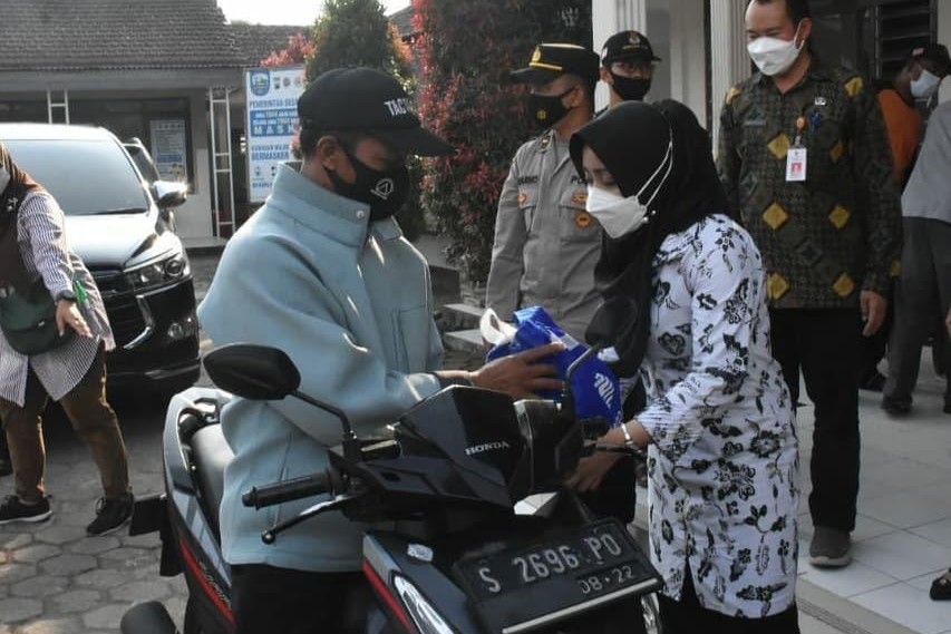Bupati Mojokerto menyerahkan bantuan sembako secara drive thru. (Foto: Deni Lukmantara/Ngopibareng.id)