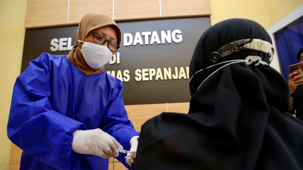 Petugas menyuntikkan vaksin Covid-19 dosis ketiga, yakni vaksin Moderna kepada para nakes di Puskesmas Sepanjang, Kecamatan Glenmore, Banyuwangi, Jawa Timur. (Foto: Istimewa)