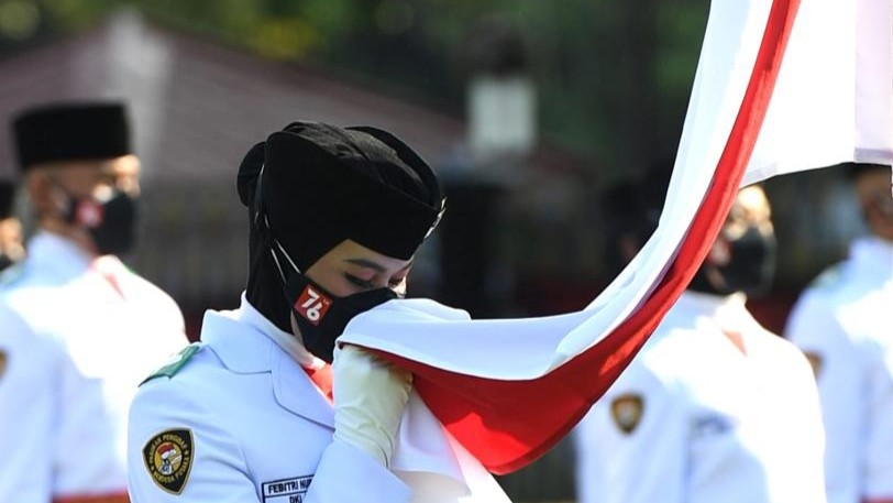 Anggota Paskibraka 2021 dari DKI Jakarta, Febitri Nur Tsabitah mencium merah putih dengan Isak tangis. (Foto: Setpres)