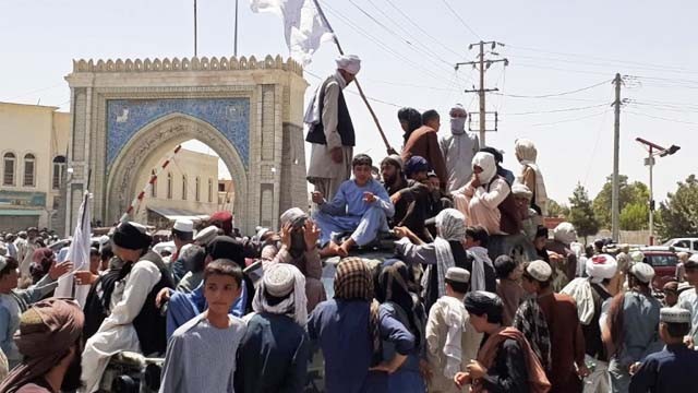    Pasukan Taliban bersuka ria di sepanjang pinggir jalan di Kota Kandahar, merayakan kemenangan setelah berhasil menduduki kota terbesar kedua di Afhanistan, Jumat kemamrin.  (Foto:AFP/Al Jazeera)
