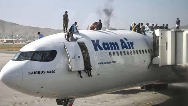 Orang-orang Afghanistan naik ke atap pesawat, di Bandara Internasional Hamid Karzai, Kabul, Afghanistan, Senin kemarin. (Foto:GulfNews)
