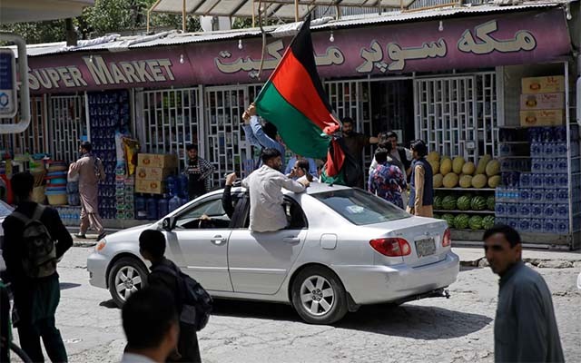 Seorang pemuda di Ibu Kota Kabul hari Kamis kemarin merayakan Hari Kemerdekaan Afghanistan dengan mengibarkan bendera lama yang terdiri tiga warna Hitam, merah dan hijau. (Foto: AP Photo/Al Jazeera) 