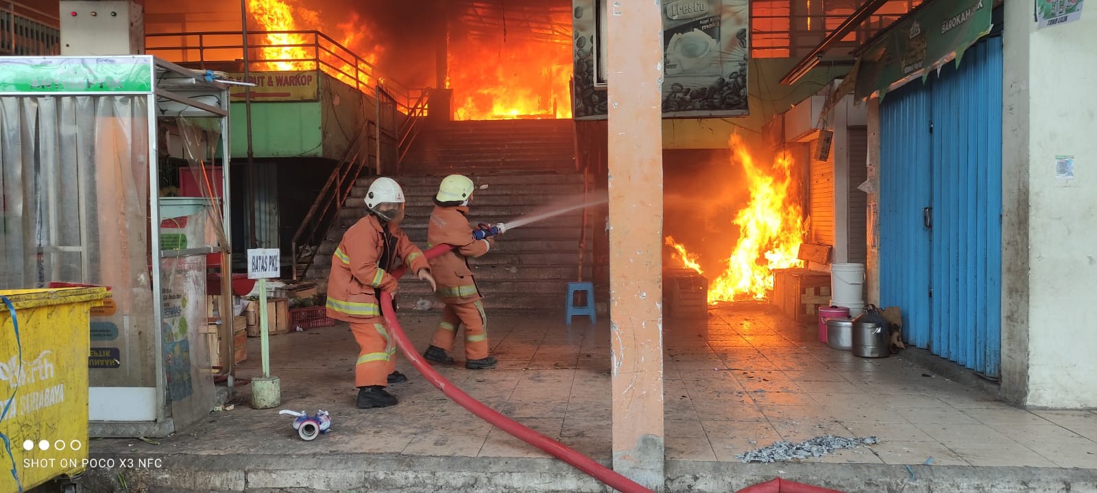 Petugas PMK Surabaya mencoba memadamkam api yang membakar lantai dua Pasar Kembang, Surabaya, Minggu 22 Agustus 2021. (Foto: PMK Surabaya)