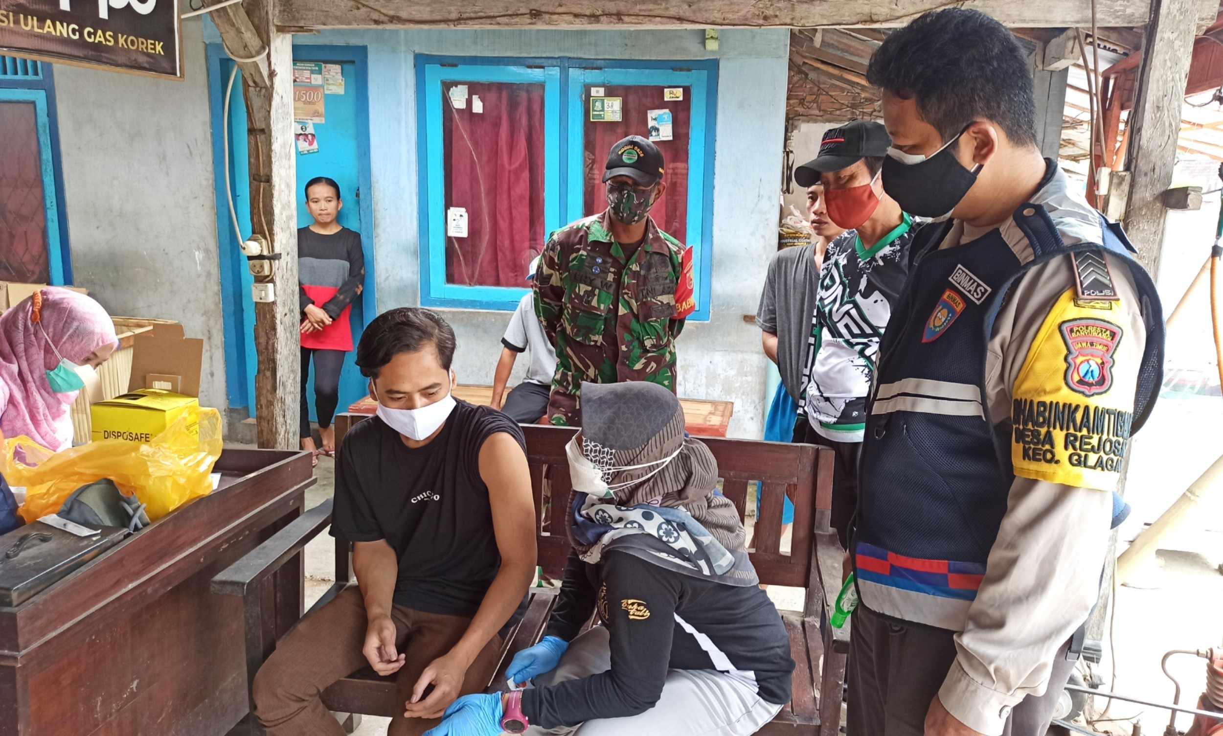 Petugas Puskesmas Paspan memberikan pemahaman kepada salah seorang penyandang disabilitas sebelum diberikan suntikan vaksin (Foto: Muh Hujaini/Ngopibareng.id)
