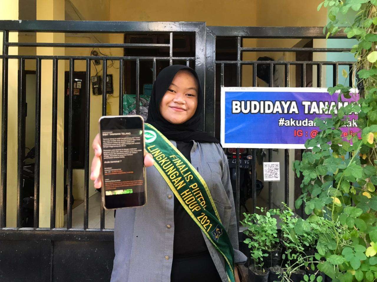 Aufaarelia Erdhinatasya Putri menunjukkan QR code yang dibuat untuk memudahkan pencarian informasi tanaman telang. (Foto: Pita Sari/Ngopibareng.id)