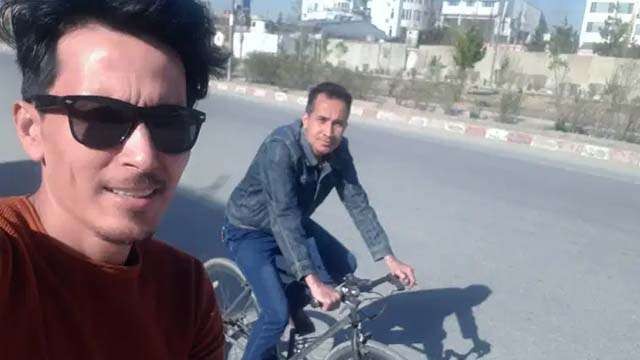 Almarhum Alireza Ahmadi (kanan), dan Zakarya Hassani, penulis,  bersepeda di Kabul pada tahun 2020. Alireza tewas akibat ledakan bom di luar Bandara Kabul 26 Agustus lalu. (Foto: Zakarya Hassani/Al Jazeera)