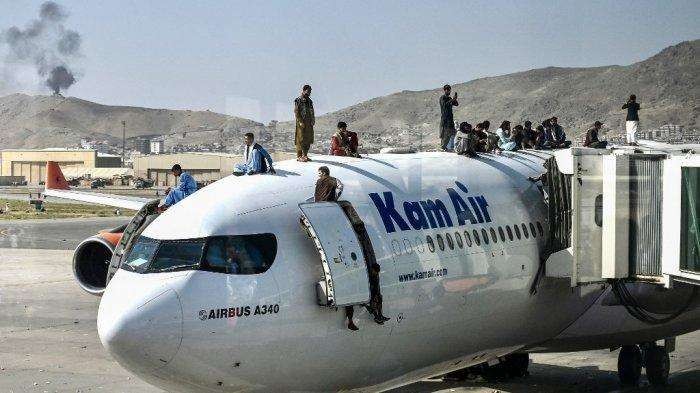 Orang-orang Afghanistan naik ke atas pesawat di Bandara Hamid Karzai Kabul pada 16 Agustus 2021, saat kemenangan Taliban. (Foto: Istimewa)