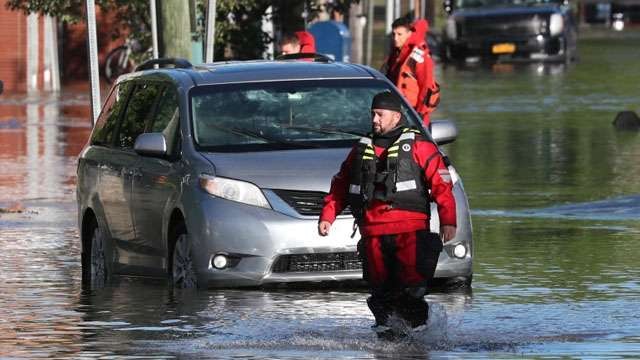    Seorang petugas ikut mengamankan kawasan Mamaroneck, New York, yang dilanda banjir hari Kamis kemarin. (Foto: Reuters/Al Jazeera)