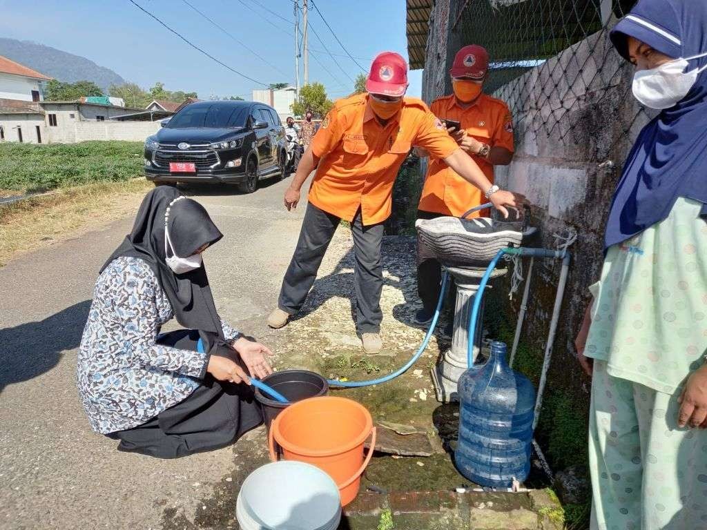 Bupati Mojokerto saat mengisi air dari tandon.(Deni Lukmantara/Ngopibareng)