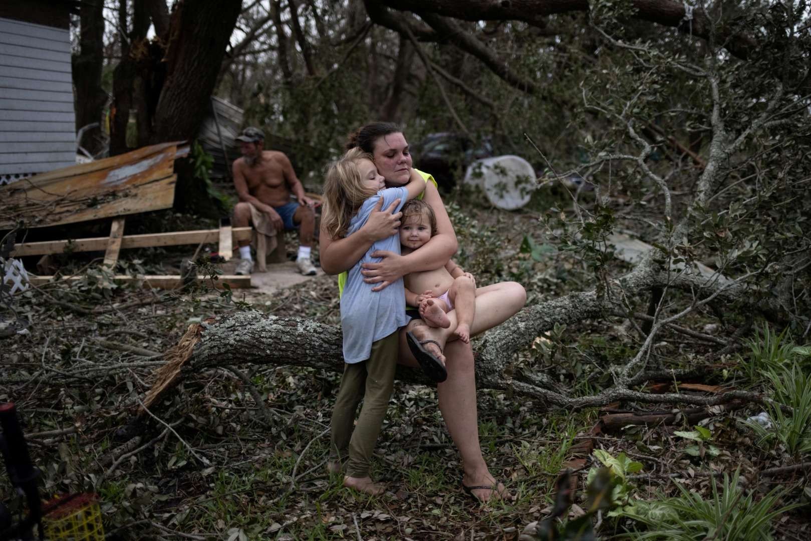 Tiffany Miller mendapat pelukan dari putrinya Desilynn, 6, sambil menggendong anak baptisnya yang baru berusia 1 tahun Charleigh, setelah keluarga tersebut kembali ke rumah mereka yang rusak akibat hantaman Badai Ida di Golden Meadow, Louisiana, Amerika Serikat, Rabu 1 September 2021. (Foto: reuters)