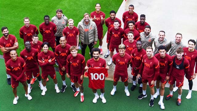 Para pemain dan staf Liverpool memberikan penghormatan kepada Mohamed Salah dengan foto bersama dan Mo Salah berada di tengah dengan jersey angka 100, pada latihan AXA Training Centre hari Senin kemarin. (Foto:LiverpoolFC)
