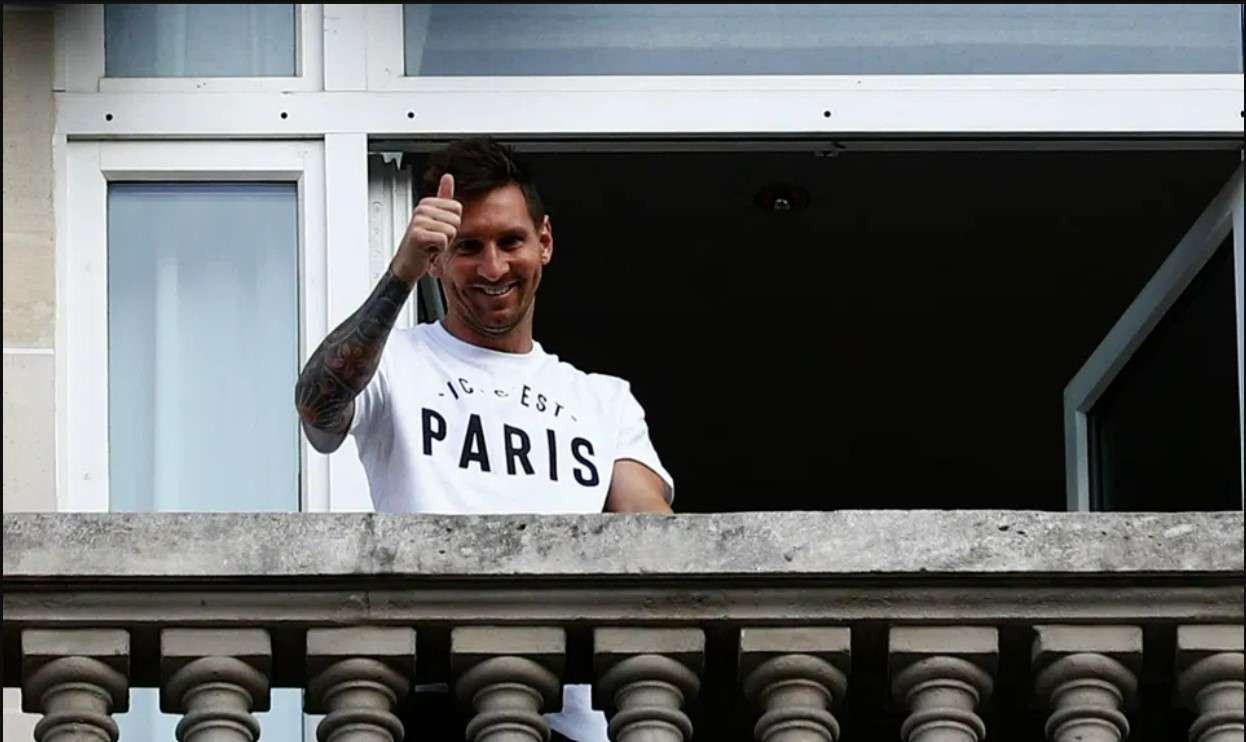 Lionel Messi saat menyapa wartawan dari balkon rumah barunya di Paris. (Foto: AP/TheSun)