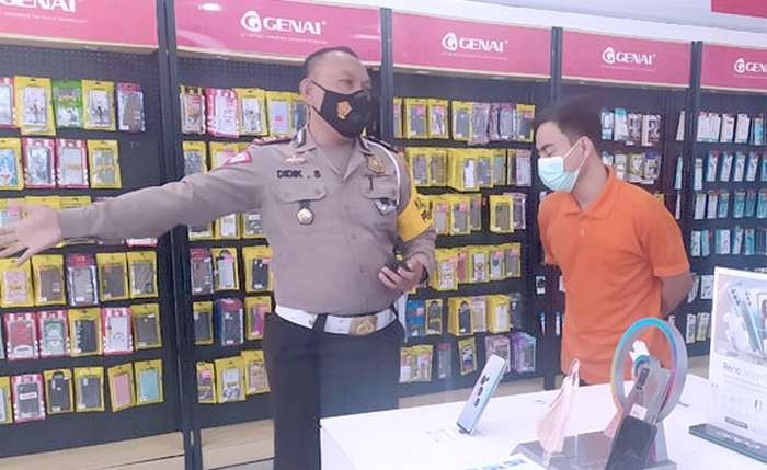 Kasat Lantas Polres Bondowoso AKP Didik Sugiarto menemui karyawan konter HP agar tidak membagikan brosur promo di badan jalan raya. (foto: istimewa).