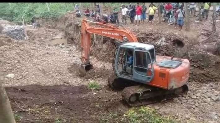 Alat berat milik DPUBMSDA Jember sedang mengeruk tanah untuk membuat jalur alternatif di Desa Mulyorejo (Foto: Istmewa)