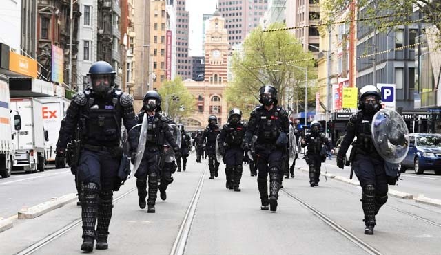 Pasukan polisi berbaris dan berpatroli di Kota Melbourne, Australia hari ini untuk berjaga setelah tiga hari kota ini dilanda unjuk rasa warga yang menolak diberlakukannya lockdown. Polisi memeriksa orang yang ditemui di jalanan. (Foto:Reuters/Al Jazeera)