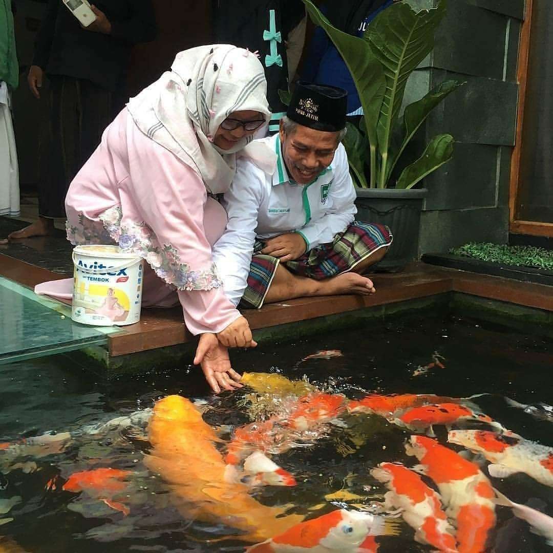 KH Marzuki Mustamar dan Nyai Hj Sa'diyah Marzuki dengan kegemarannya memelihara ikan. (Foto: Istimewa)